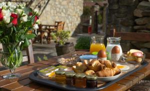 a tray of food on a table with eggs and bread at Παραδοσιακός Ξενώνας Ραχάτι in Órma