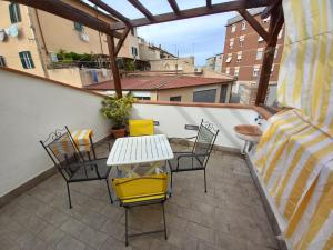 een patio met een tafel en stoelen op een balkon bij "La Casita", 2 Floors Apartment, Private Parking 1 car OR 2 Bikes, Air-Cond and Terrace in Livorno