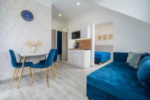 uma sala de estar com um sofá azul e uma mesa em pokoje goscinne i apartamenty Margaret em Kudowa-Zdrój