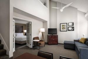 um quarto de hotel com uma cama, um sofá e uma televisão em Residence Inn Seattle North/Lynnwood Everett em Lynnwood