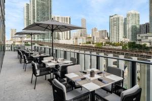a row of tables with umbrellas on a roof at AC Hotel By Marriott Miami Brickell in Miami