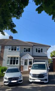 two cars parked in a parking lot in front of a house at West Kirby home for Open golf at Hoylake in West Kirby