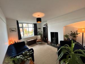 sala de estar con sofá azul y chimenea en West Kirby home for Open golf at Hoylake en West Kirby