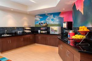 a kitchen with wooden cabinets and fruit on the counter at Fairfield Inn & Suites Greeley in Greeley