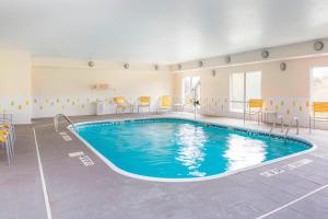 a large pool in a room with chairs and tables at Fairfield Inn & Suites Greeley in Greeley