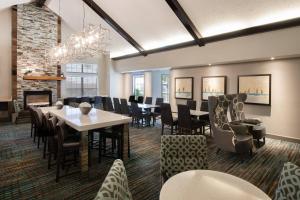 comedor con mesas y sillas y chimenea en Residence Inn by Marriott Jacksonville Butler Boulevard, en Jacksonville