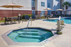een zwembad met een tafel en een parasol bij Residence Inn by Marriott Jacksonville Butler Boulevard in Jacksonville