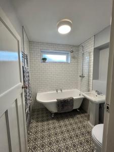 La salle de bains est pourvue d'une baignoire, de toilettes et d'un lavabo. dans l'établissement West Kirby home for Open golf at Hoylake, à West Kirby