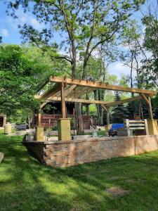 un pavillon en bois dans un parc avec des arbres et de l'herbe dans l'établissement Tiny Cabin located on the outskirts of Mohican State Park, 