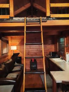 - un salon avec des lits superposés et un canapé dans l'établissement Tiny Cabin located on the outskirts of Mohican State Park, 