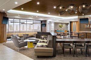 um átrio do hotel com um bar e mesas e cadeiras em SpringHill Suites by Marriott Oklahoma City Midwest City Del City em Del City