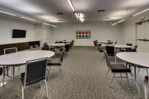 a room with tables and chairs and a tv at Element Ewing Princeton in Ewing