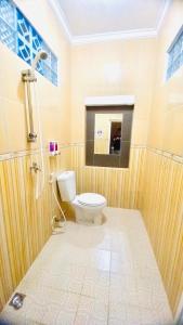 La salle de bains est pourvue de toilettes et d'un miroir. dans l'établissement Ahlen Pangandaran, à Pangandaran