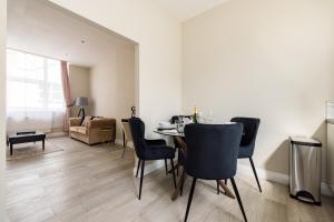 a living room with a dining room table and chairs at Avari Apartments - Hatton Collection in London