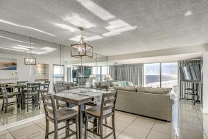 a dining room and living room with a table and chairs at Forest Dunes Penthouse 1801 in Myrtle Beach