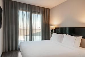A bed or beds in a room at AC Hotel Atocha by Marriott