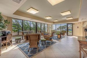 a lobby with tables and chairs and windows at Forest Dunes Penthouse 1801 in Myrtle Beach