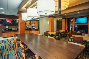 een grote eetkamer met een grote houten tafel en stoelen bij Fairfield Inn and Suites by Marriott Muskogee in Muskogee