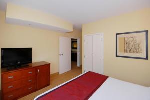 a bedroom with a bed and a flat screen tv at Courtyard by Marriott Vicksburg in Vicksburg