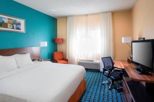 Fairfield Inn & Suites Peru في Peru: غرفة فندقية فيها سرير ومكتب وتلفزيون