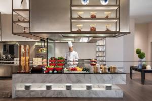 a chef standing behind a counter in a kitchen at Courtyard Taiyuan in Taiyuan