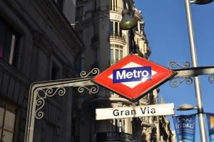 una señal de metro está pegada a un semáforo en Hostal Meyra, en Madrid