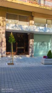 a building with a tree in front of a building at Penthouse Pyrgos Centre Olympia in Pyrgos