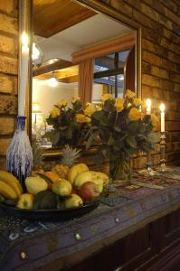 une assiette de fruits sur une table devant un miroir dans l'établissement Elonda B&B, à Pretoria