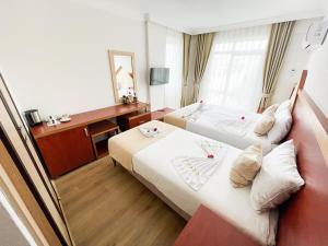 a hotel room with two beds and a desk at Far Life Hotel in Antalya