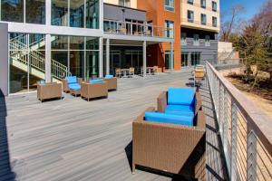 a deck with chairs and tables on a building at Fairfield Inn & Suites by Marriott Rehoboth Beach in Rehoboth Beach