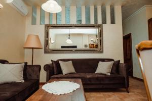un soggiorno con divano marrone e specchio di Aquapalic Resort a Palić