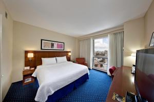 a hotel room with a bed and a large window at Courtyard by Marriott San Juan Miramar in San Juan