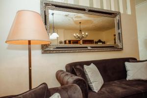 een woonkamer met een bank en een spiegel bij Aquapalic Resort in Palić