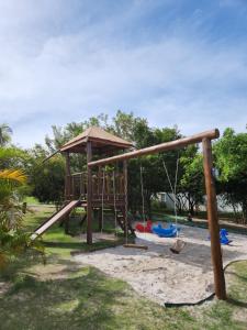 einen Spielplatz mit einer hölzernen Schaukel in einem Park in der Unterkunft Paraíso na Reserva Imbassaí in Mata de Sao Joao