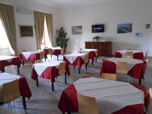 une salle à manger avec des tables et des chaises rouges et blanches dans l'établissement Sacro Cuore Opera Don Guanella, à Torre Canne