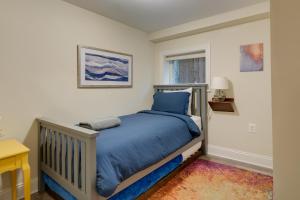 a bedroom with a bed with a blue comforter at Washington DC Apartment at Rock Creek Park! in Washington, D.C.