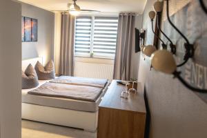 um pequeno quarto com uma cama e uma janela em Pension Village em Naumburg