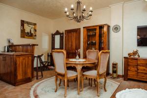 una sala da pranzo con tavolo, sedie e lampadario pendente di Aquapalic Resort a Palić