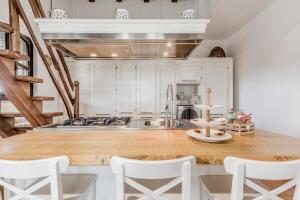 a kitchen with white cabinets and a wooden counter top at B&B A casa di Giulia in Guidonia