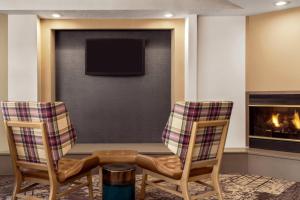 sala de estar con 2 sillas y chimenea en Residence Inn by Marriott Philadelphia West Chester/Exton, en Exton