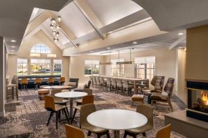 a restaurant with tables and chairs and a fireplace at Residence Inn by Marriott Philadelphia West Chester/Exton in Exton