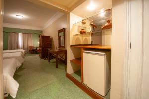 ein Hotelzimmer mit einem Bett, einem Schreibtisch und einer Küche in der Unterkunft Granados Park Hotel in Asunción