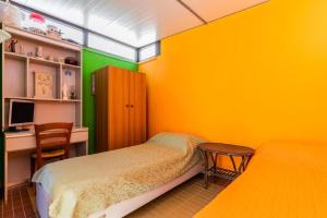 a bedroom with yellow walls and a desk and a bed at ATTICO SUL MARE in Gallipoli