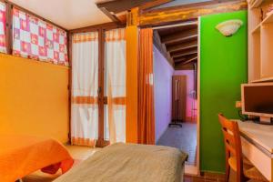 a bedroom with green and yellow walls and a television at ATTICO SUL MARE in Gallipoli