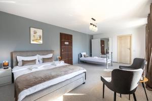 a bedroom with a large bed and a chair at Vila Emerald Residence in Râşnov +89 photos