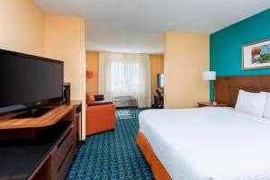 a hotel room with a bed and a flat screen tv at Fairfield Inn & Suites Lincoln in Lincoln