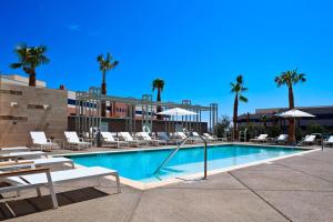 a pool with chairs and umbrellas in a resort at Element Las Vegas Summerlin in Las Vegas