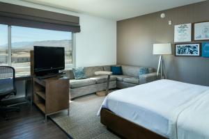 a hotel room with a bed and a couch and a television at Element Las Vegas Summerlin in Las Vegas