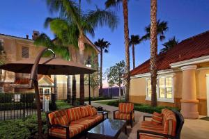 une terrasse avec des chaises, une table et un parasol dans l'établissement Residence Inn Anaheim Hills Yorba Linda, à Anaheim