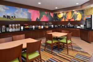 a restaurant with two tables and chairs and a counter at Fairfield Inn & Suites Louisville North in Jeffersonville